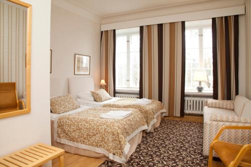 a hotel room with a bed and a couch at Hotelli-Ravintola Mäntän Klubi in Mänttä