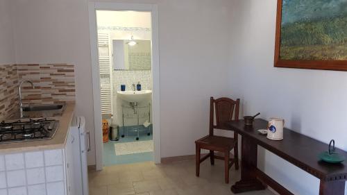 a kitchen with a counter and a sink and a table at B&B Le Due Corti in Martignano