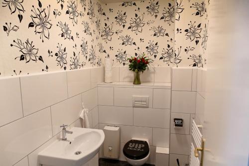a bathroom with a sink and a vase of flowers at Suite-Apartment-Essen in Essen