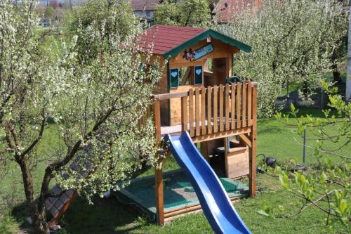 un parque infantil con tobogán y una casa de juegos en Pension Berghof, en Brannenburg