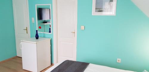 a room with a bed and a white cabinet and a door at Joy Guesthouse in Siófok