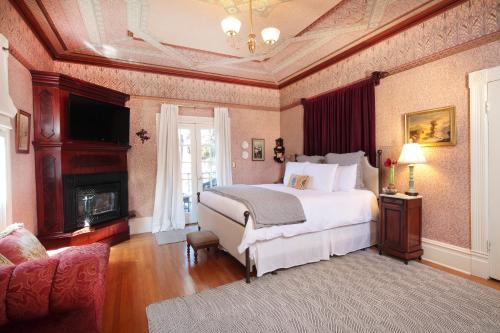 a bedroom with a large bed and a fireplace at Calderwood Inn in Healdsburg