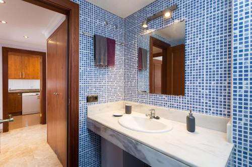 ロス・クリスティアーノスにあるEl Anclaの青いタイル張りのバスルーム(シンク、鏡付)