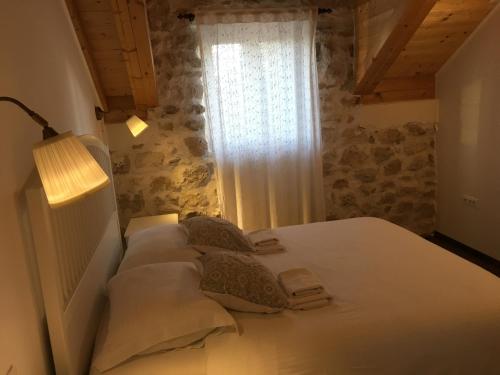 a bedroom with a white bed with a window at Holiday Home Cvita in Lozovac
