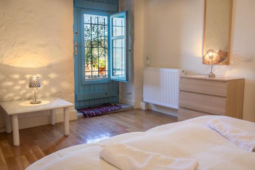 Un dormitorio con una cama y una ventana y una mesa. en Villa Smaragda, en Limeni
