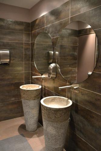 a bathroom with two sinks and a mirror at Greenhotels Roissy Parc des Expositions in Tremblay En France