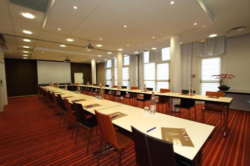 a large conference room with tables and chairs at Greenhotels Roissy Parc des Expositions in Tremblay En France