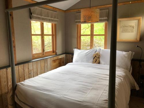 a teddy bear sitting on a bed in a bedroom at Faraway Follies in Llandegla