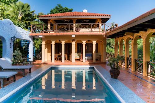 a house with a swimming pool in front of a house at Reef View Pavilions - Villas & Condos in Lance aux Épines