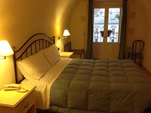 a bedroom with a large bed in a room at Hotel Relais Modica in Modica