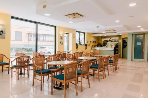a row of tables and chairs in a restaurant at Hotel Villa Claudia in Bellaria-Igea Marina