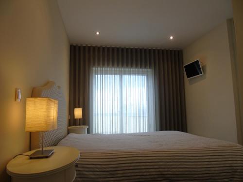 سرير أو أسرّة في غرفة في Oporto Beach