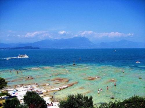a group of people in the water at a beach at Villa Paradiso Apartment in Sirmione