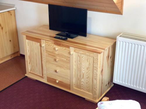 a wooden entertainment center with a television on top of it at Penzion Zrzka in Kořenov