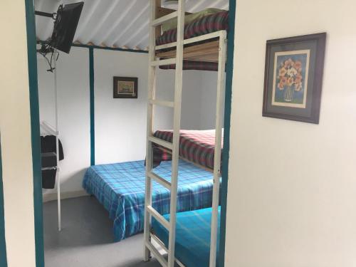 a room with a bunk bed and a ladder at La cabaña del lago Calima in Calima