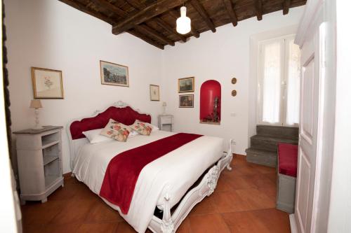 ein Schlafzimmer mit einem großen Bett mit einer roten und weißen Tagesdecke in der Unterkunft Il Valentino in Castel Gandolfo