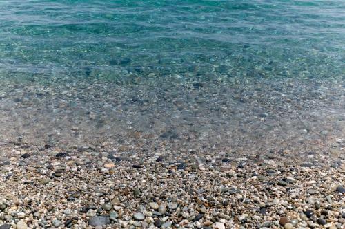 a sandy beach with rocks and the water at Atlantis Palace Hotel in Mascali