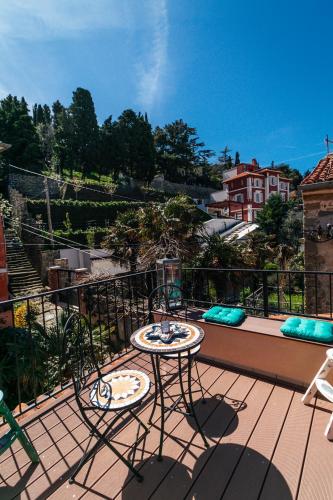 Un patio con una mesa y sillas en un balcón. en Apartments Lara with more affordable parking, en Piran