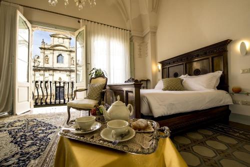 a hotel room with a bed and a table with a tea set at Palazzo Guido in Lecce