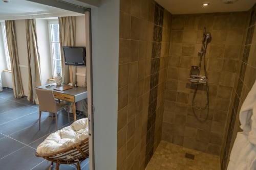 a bathroom with a shower and a desk with a computer at Hotel Jean Moët in Épernay