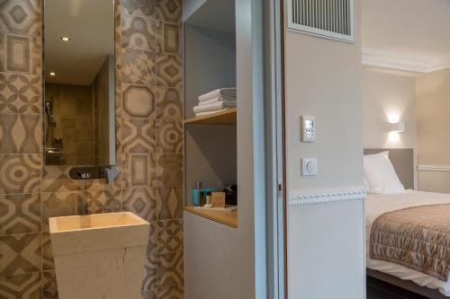 a small bedroom with a bed and a bathroom at Hotel Jean Moët in Épernay