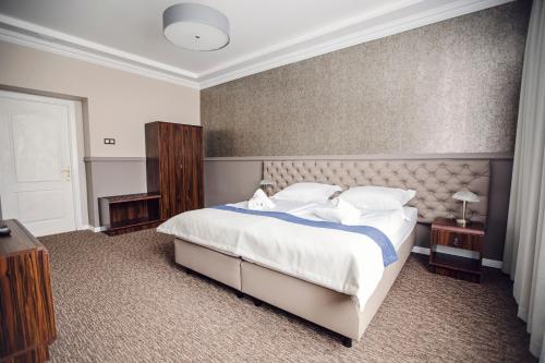 a bedroom with a large bed with white sheets and pillows at Bristol Residence in Bytom