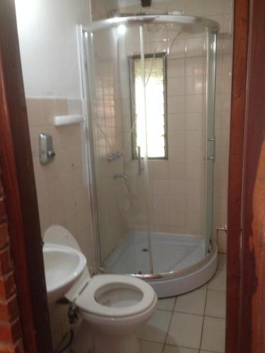 a bathroom with a toilet and a shower and a sink at Zorzal 1 in Puerto Rico