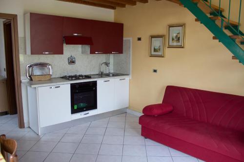 a living room with a red couch and a kitchen at Casa Ornella in Ponte Caffaro