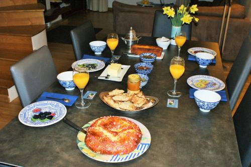 une table avec des assiettes de nourriture et des verres de jus d'orange dans l'établissement L'Oustau de Pequeti, à Laboule