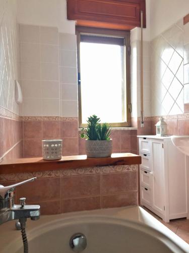 a bathroom with a tub and a sink and a window at La casa del Professore in Tortora