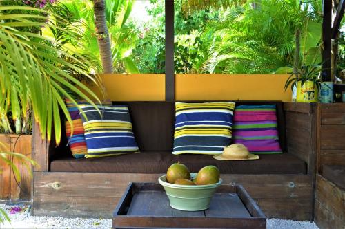 a couch with pillows and a bowl of fruit on a table at Jan Kok Lodges in Willibrordus