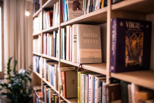 a book shelf filled with lots of books at Hotel garni Kranzbichlhof in Dürrnberg