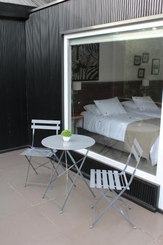 a bedroom with a bed and a table and chairs at Fresia Suite in Pucón