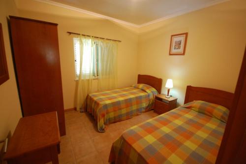 a hotel room with two beds and a window at Apartamento Patel in Poço Partido