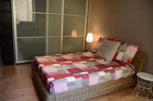 een slaapkamer met een bed met een geruite deken bij calme et charme in Avignon