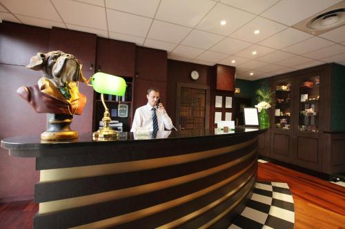 a man talking on a cell phone at a bar at Greenhotels Roissy Parc des Expositions in Tremblay En France