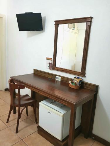 a wooden desk with a mirror and a chair at Casa do Manequinho Hotel e Restaurante in Piraí