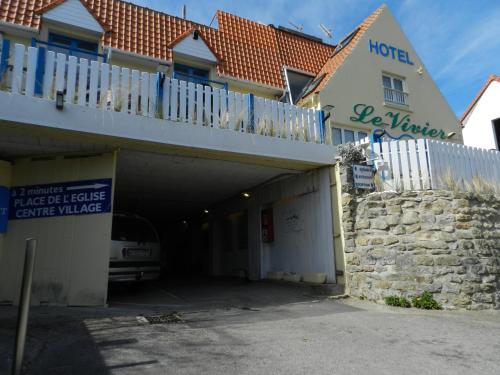 a building with a garage with a car parked in it at Hôtel Le Vivier WISSANT - Vue Mer - Côte d'Opale - Baie de Wissant - 2CAPS in Wissant