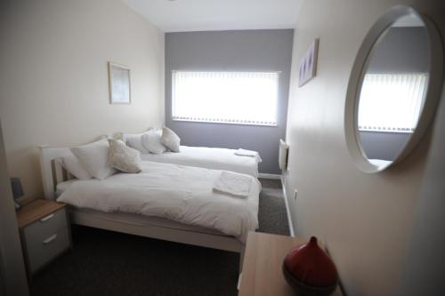 a small bedroom with two beds and a mirror at Liverpool 2 Bedroom Apartment in Liverpool