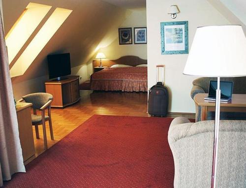 a hotel room with a bed and a couch and a lamp at Hotel Bielany in Bielany Wrocławskie