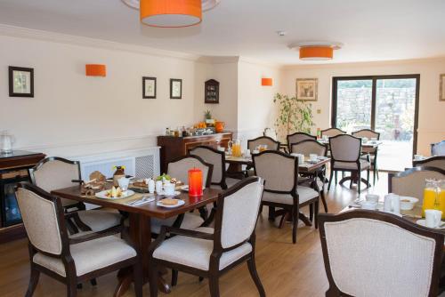 een eetkamer met tafels en stoelen bij Hazelwood Lodge in Ballyvaughan