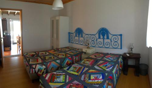 1 Schlafzimmer mit 2 Betten und bunten Decken in der Unterkunft Azorean Cottage São Jorge in Cais da Urzelina