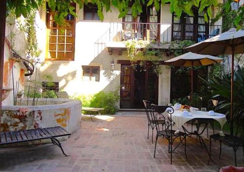 a patio with a table and chairs and an umbrella at Cissus Hotel Boutique in Antigua Guatemala