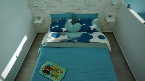 a bed with blue and white pillows and a tray of food at THE BLUE VIEW MASPALOMAS in San Agustin