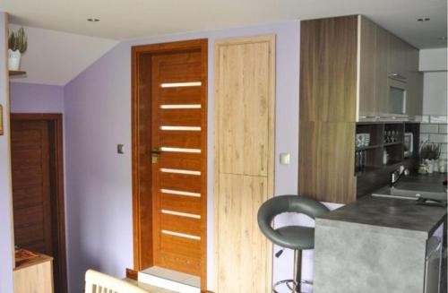 uma cozinha com uma porta de madeira e uma cadeira preta em Nocleg w Małastowie em Małastów