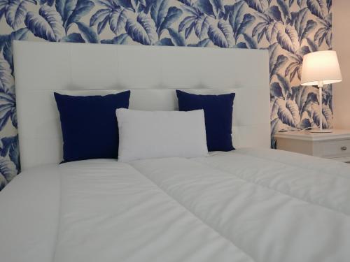 ナザレにあるCasa da Lalaのベッドルーム1室(白と青の壁紙を使用した白いベッド1台付)