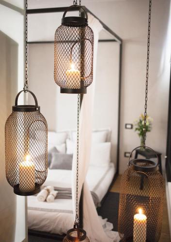 two hanging cages with candles in a bedroom at Stay In Ortigia in Siracusa