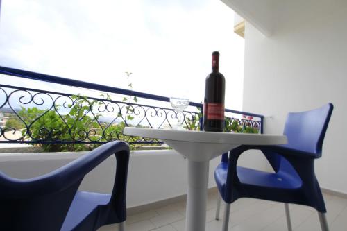 
a table with a glass of wine and a bottle of wine at Christiana Hotel Apartments in Gennadi
