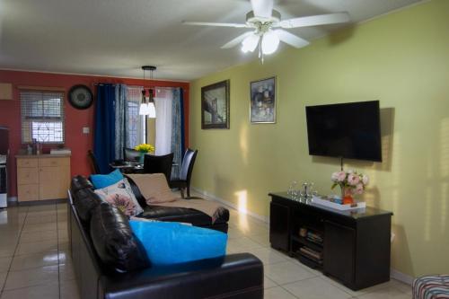 a living room with a couch and a flat screen tv at Country Club Comfort in Portmore