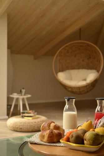 a table with a plate of bread and a basket of milk at Le Fontanelle B&B in Sarno